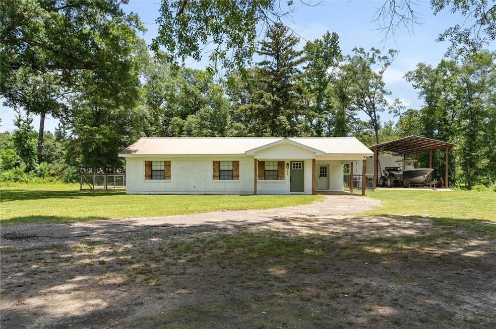 View of front of home with a carport and dirt driveway