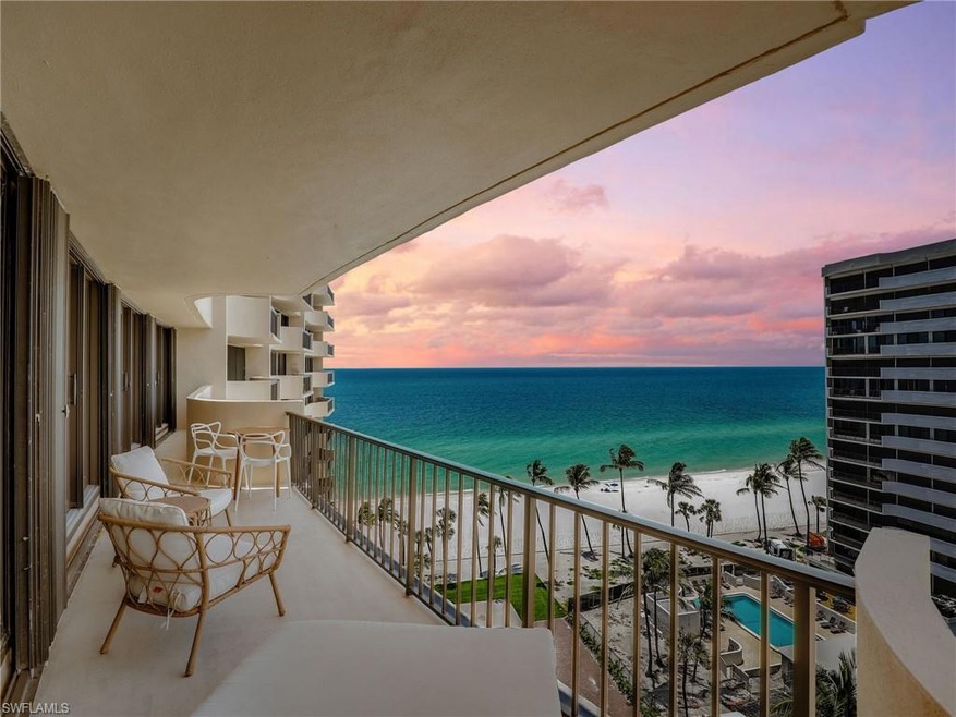 Balcony at dusk with view of water and beach