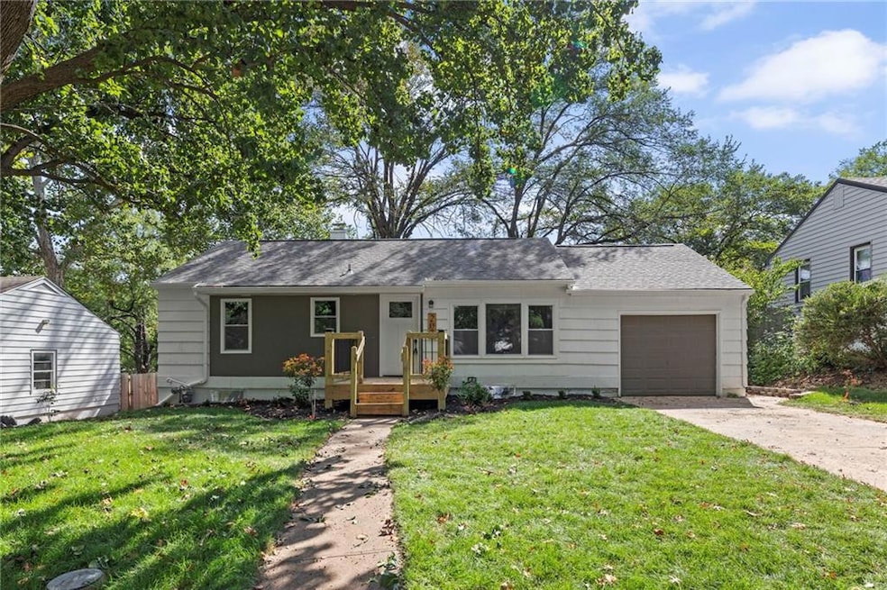 Single story home with a front yard, a garage, driveway, and a shingled roof