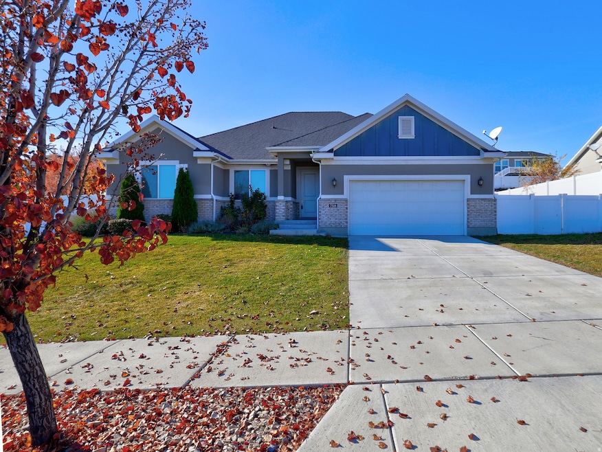 View of front facade featuring brick siding, concrete driveway, board and batten siding, and an attached garage