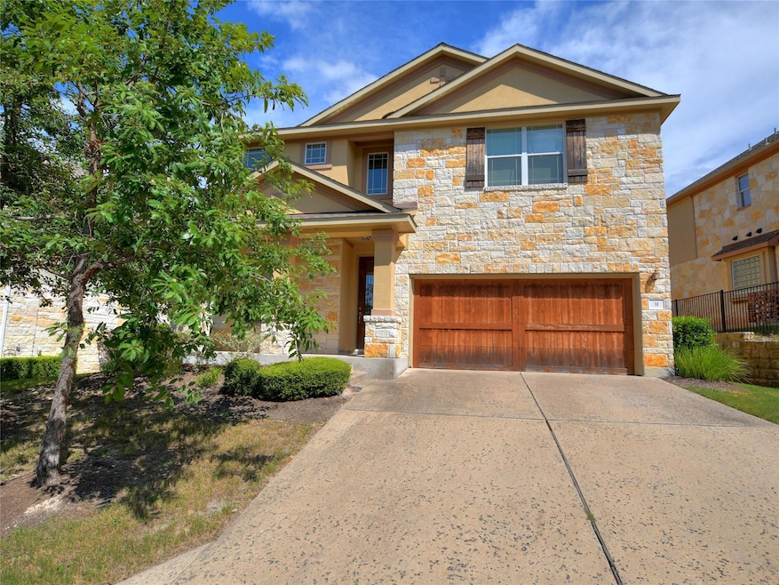 Craftsman-style home with stone siding, a garage, and driveway