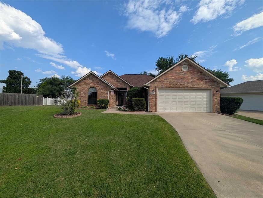 Ranch-style home with brick siding, driveway, and an attached garage