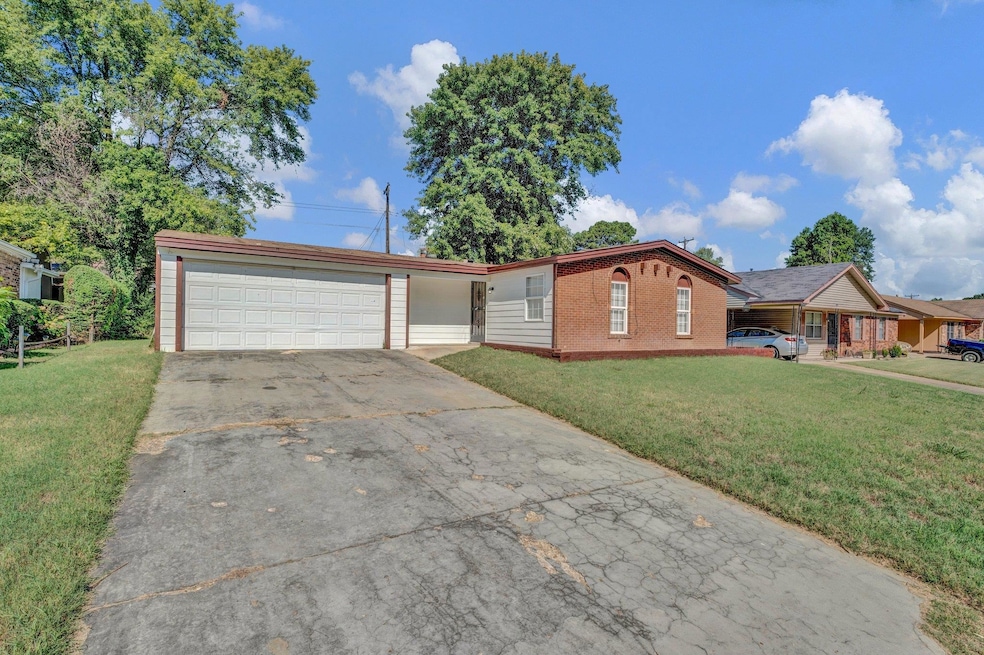 Ranch-style home featuring a garage and a front ya