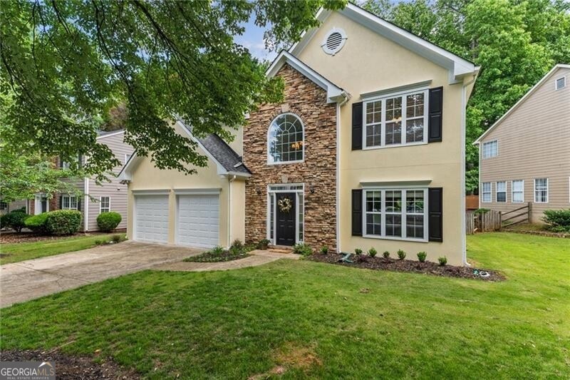 View of front of home with a front yard and a gara