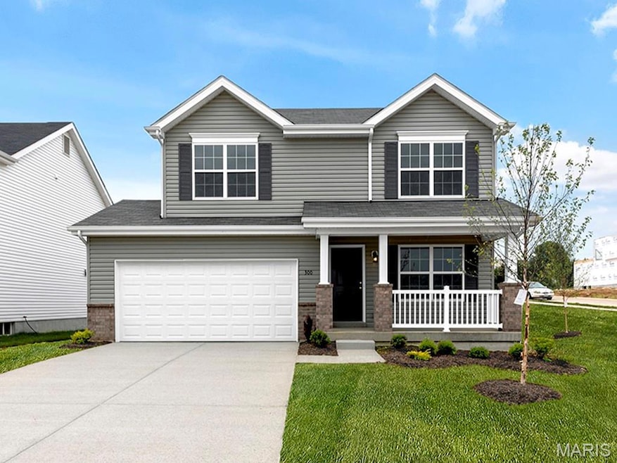 View of front of home featuring a porch, driveway, a garage, brick siding, and a front yard
