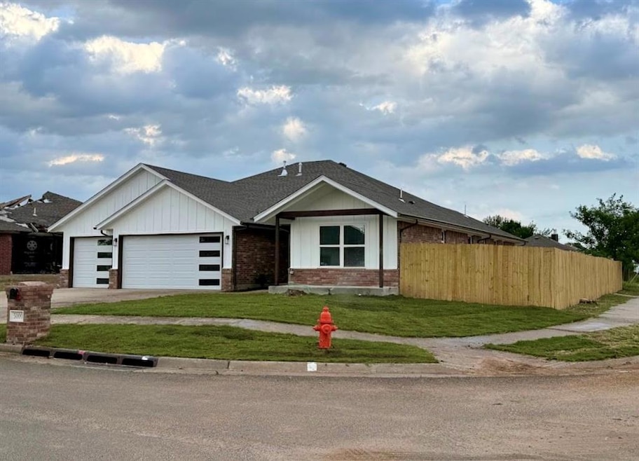 View of front of home with a garage, brick siding, a shingled roof, asphalt driveway, and board and batten siding