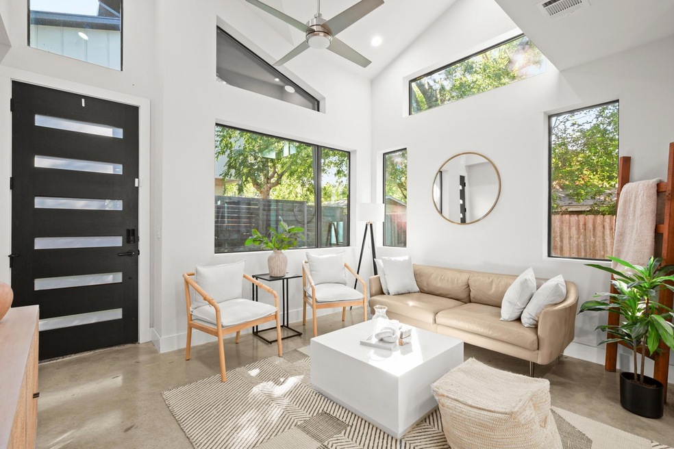 Living room with concrete floors, high vaulted ce