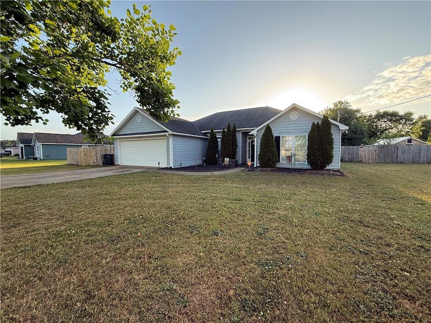 Ranch-style house with driveway, fence, and a fron