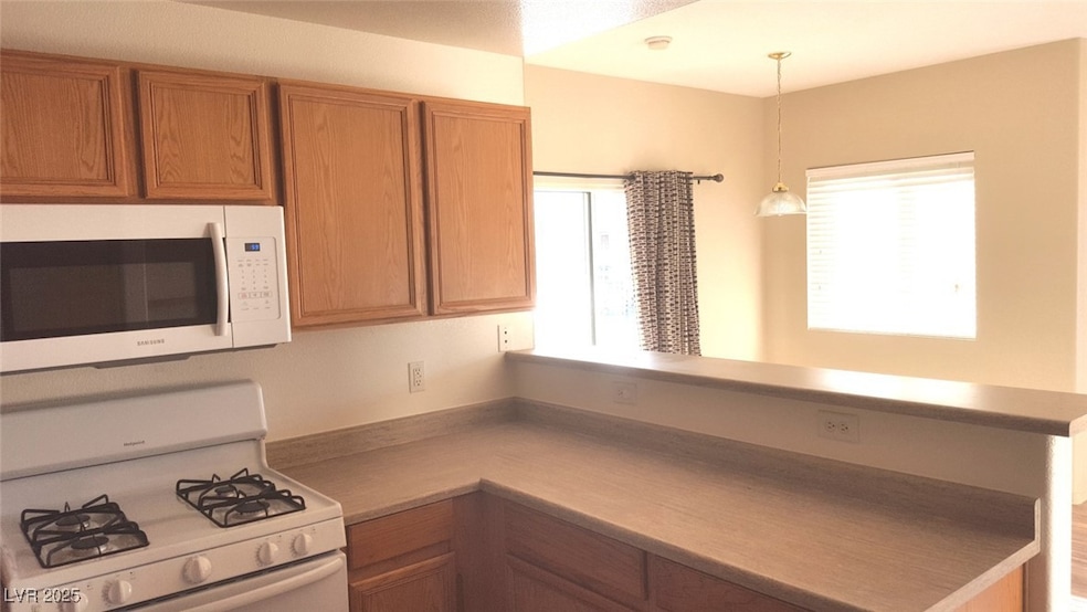 Kitchen featuring white appliances, a peninsula, p