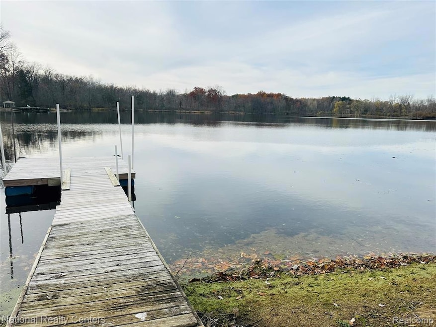 Dock area featuring a water view and a forest view