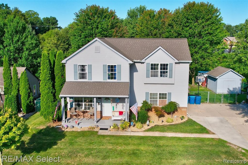 Traditional-style house featuring covered porch, roof with shingles, and brick siding