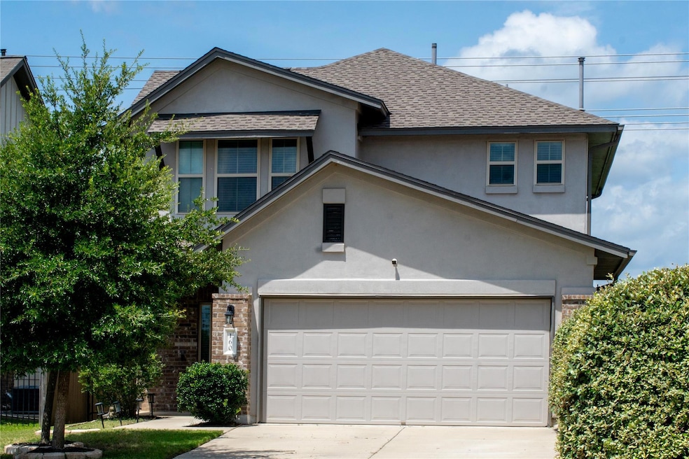 View of front of home with a shingled roof, concr