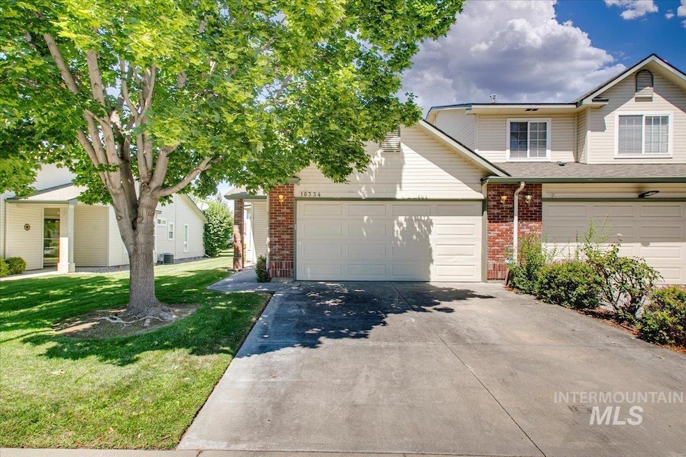 View of front facade featuring brick siding, concrete driveway, a front yard, and a garage