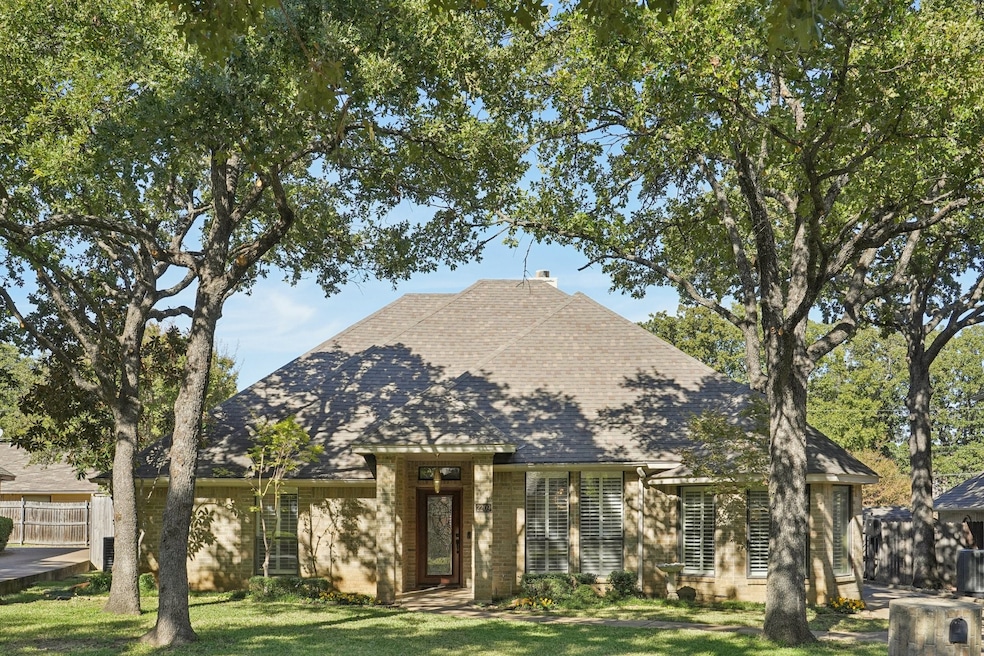View of front of home with roof with shingles and brick siding