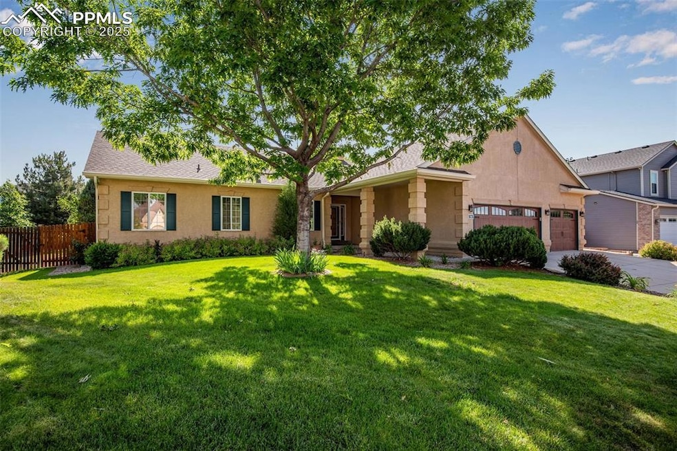 View of front of the house with stucco siding, 3-car garage, concrete driveway, and mature landscaping