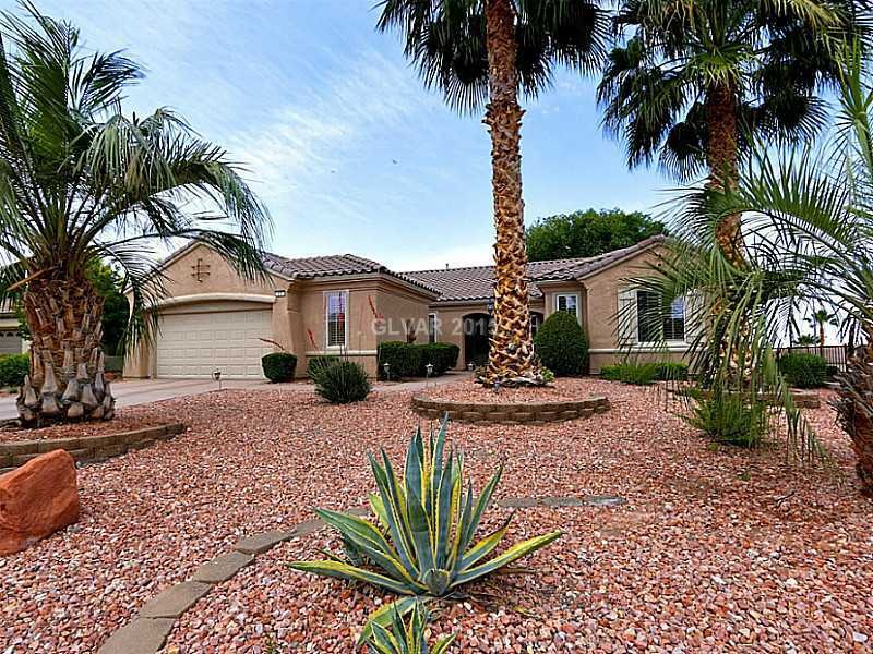 Facade/Exterior Front. Liberty on an Elevated Lot with Mountain Views. Two Car + Golf Cart Garage that is Air Cooled.  Professional Landscape with Mature Desert Palm Trees.