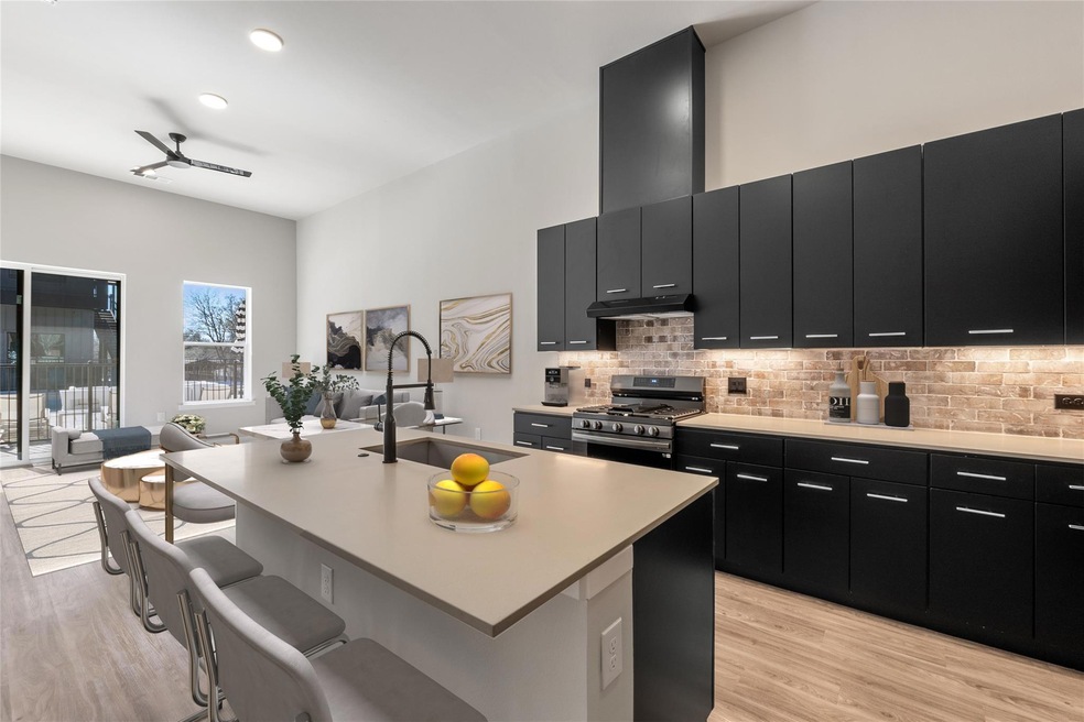 Kitchen featuring dark cabinetry, light wood fini