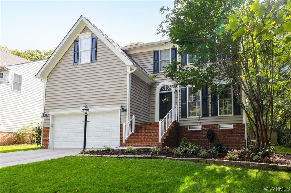 View of front of house with a garage and a front y