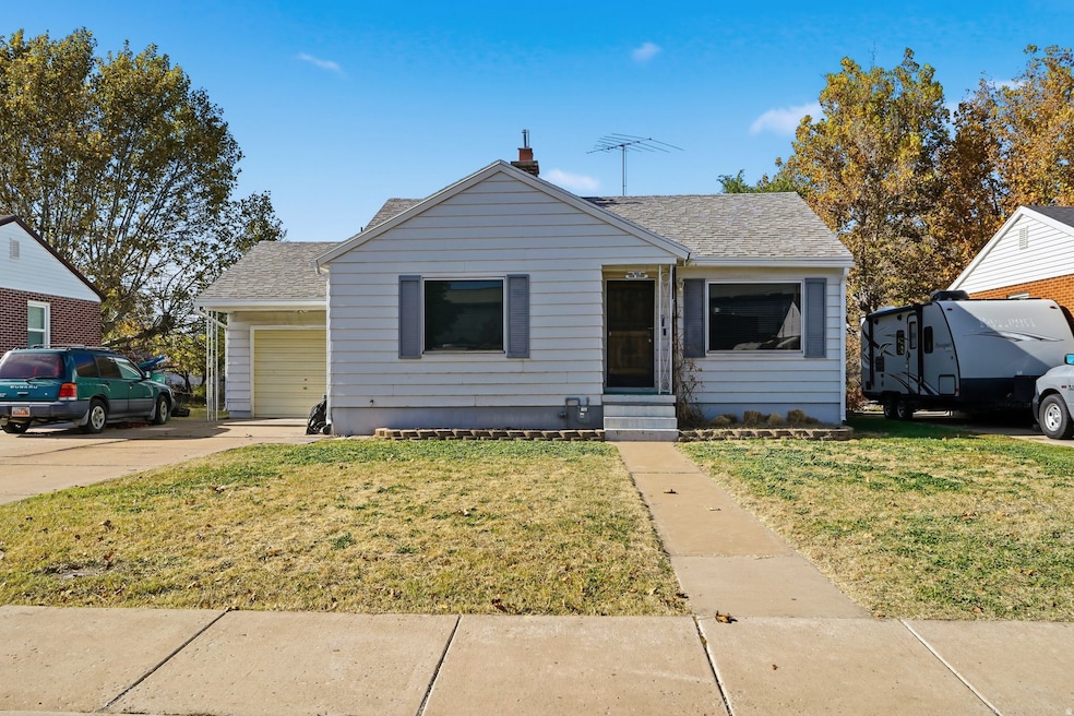 Bungalow-style home featuring a front lawn, roof with shingles, entry steps, and an attached garage