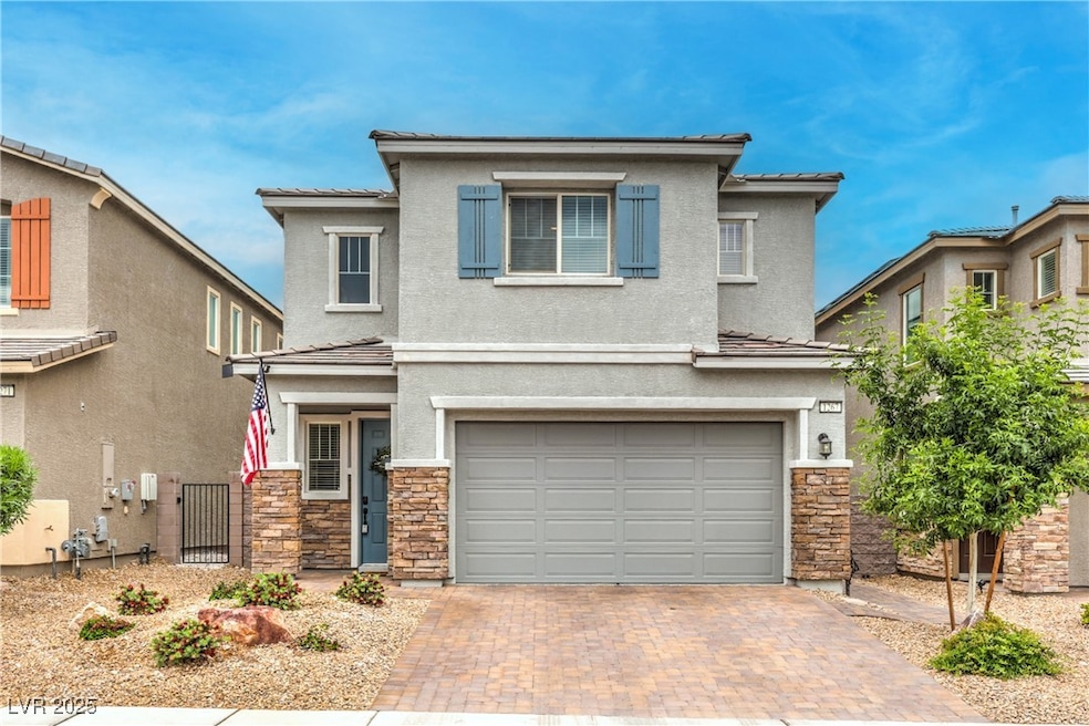 View of front of house with stone siding, an attac