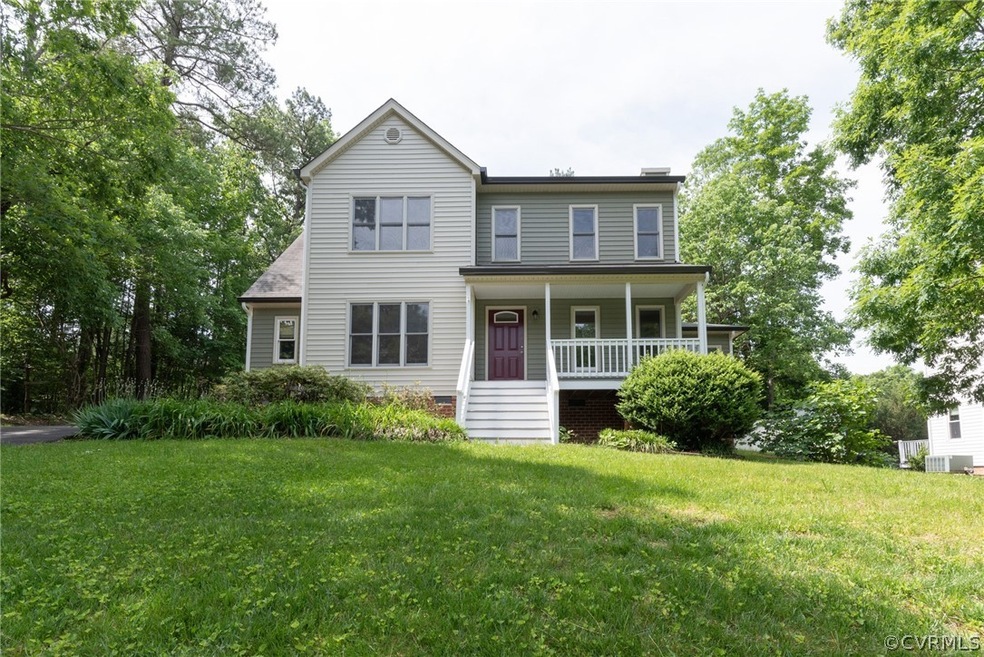 Colonial house with a front yard and covered porch