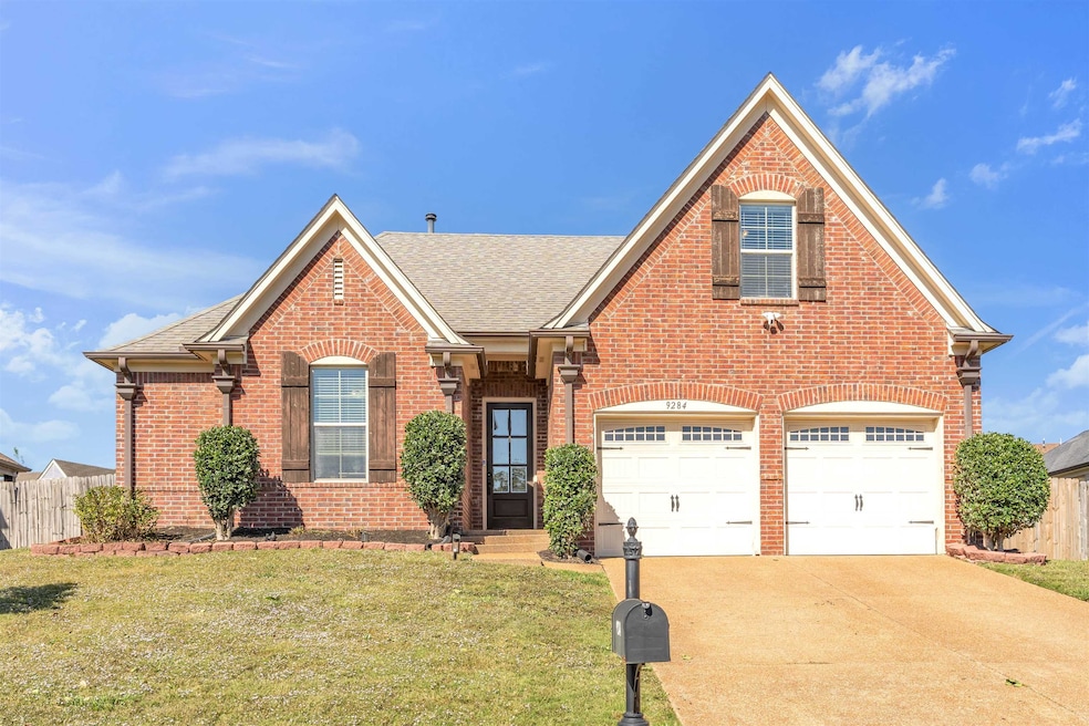 Traditional-style house featuring brick siding, a shingled roof, concrete driveway, and a garage