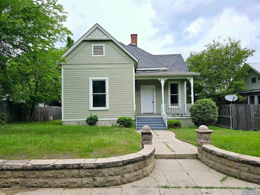 Victorian house featuring a porch, fence, and a fr