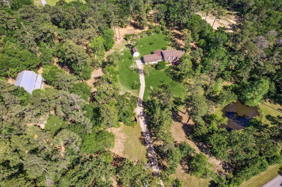 Aerial photo of the property with home and pond on