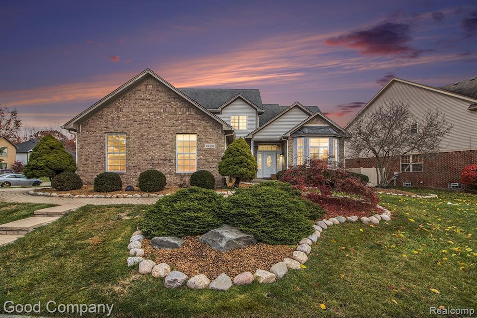 Traditional home with a front yard, brick siding, and a shingled roof