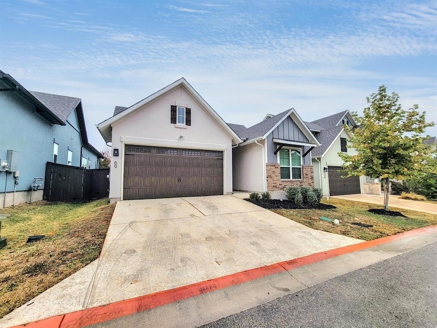 View of front of property with driveway and stucco siding
