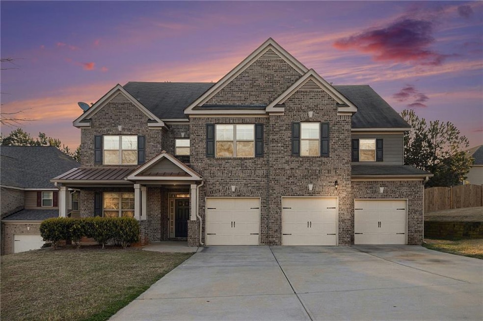 View of front facade with driveway, a garage, brick siding, and covered porch