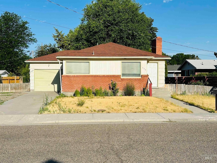 Ranch-style house featuring concrete driveway, brick siding, an attached garage, and roof with shingles