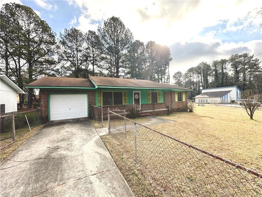 Ranch-style house with a front yard and a garage