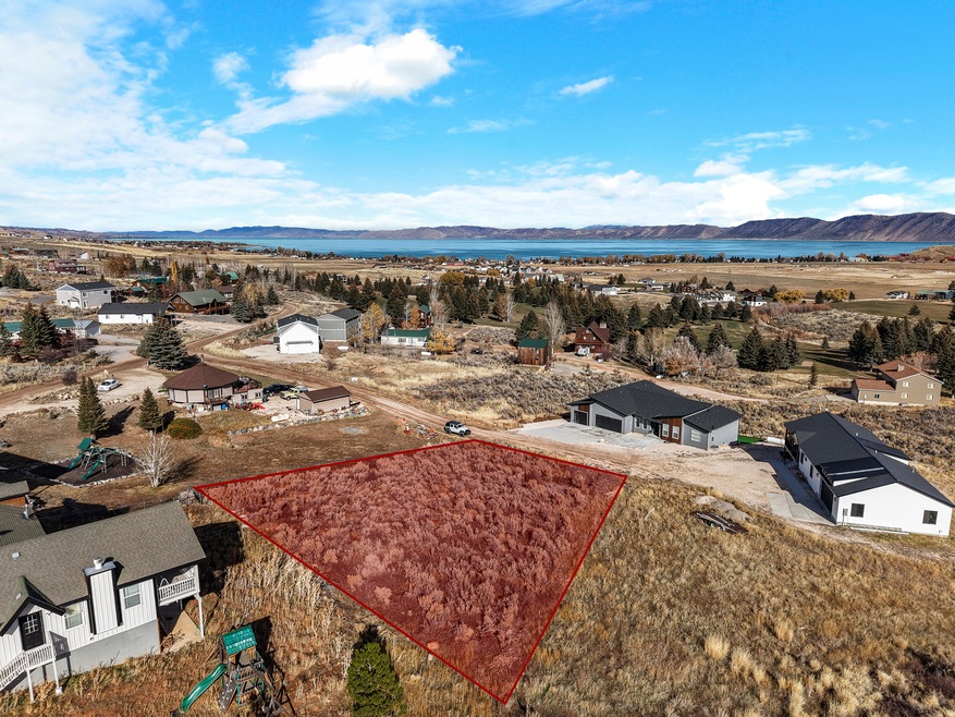 Aerial view of property and surrounding area featuring property parcel outlined and a water and mountain view