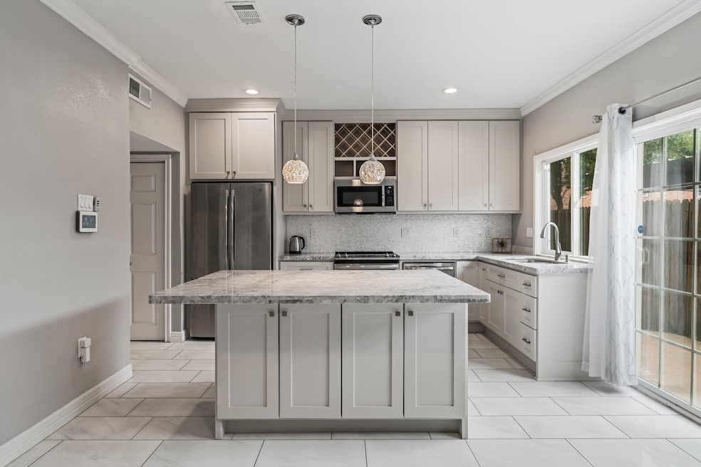 This modern kitchen features sleek cabinetry, stai