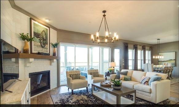 Living room of model.  Using same lighting and colors. Brick fireplace. 