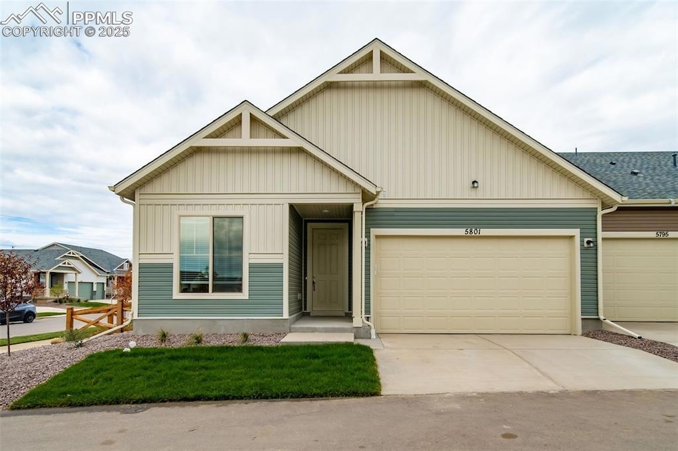 View of front of property featuring concrete driveway, a garage, a front lawn, and board and batten siding