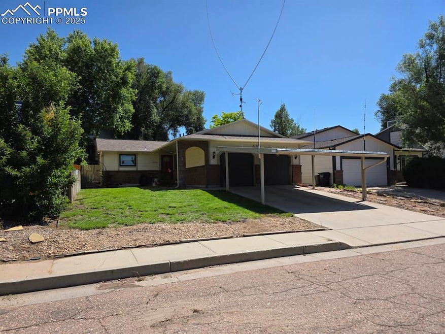 View of front of home featuring a garage, a front lawn, concrete driveway, and brick siding