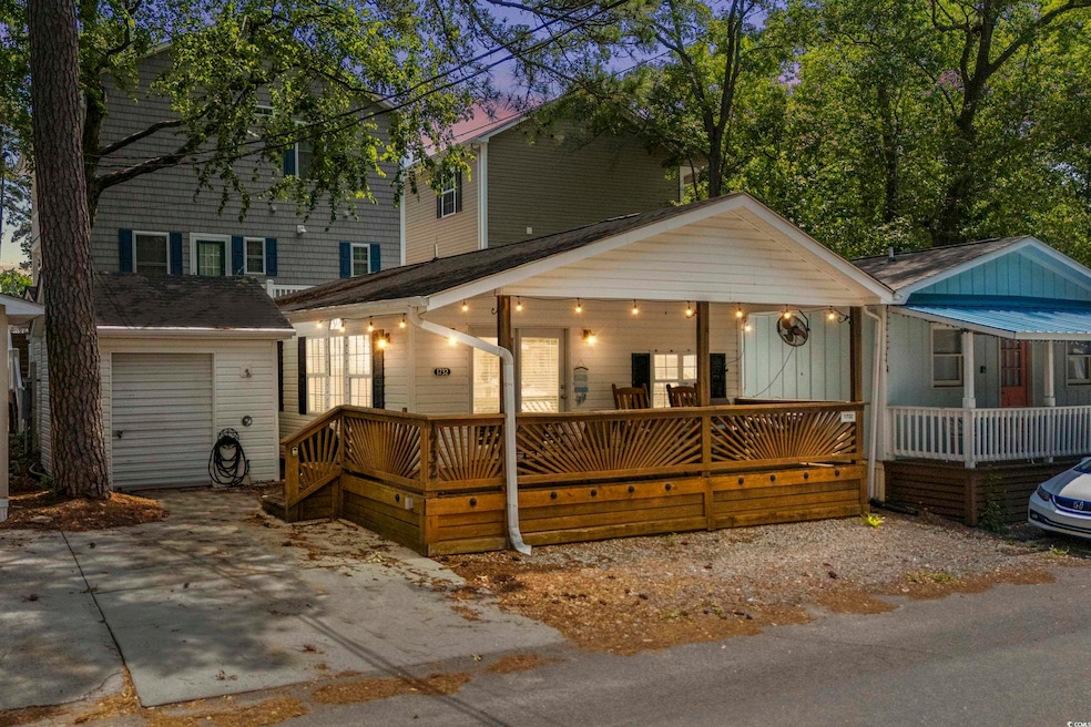 View of front facade with a porch, an outdoor structure, and a garage