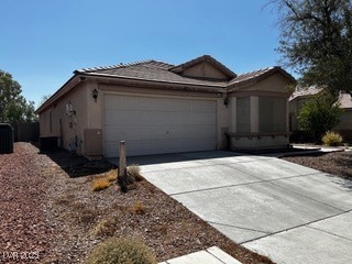 Ranch-style house featuring a garage, driveway, and stucco siding