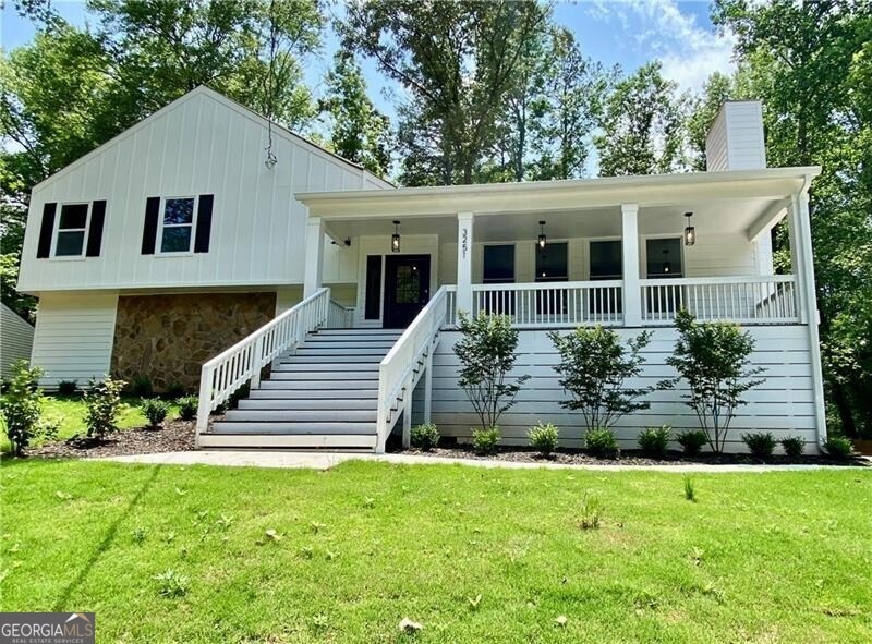 View of front of home with a front yard and covere