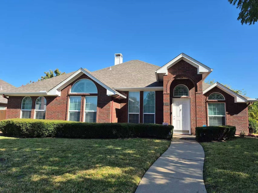 Ranch-style house featuring a front lawn, brick siding, a chimney, and roof with shingles