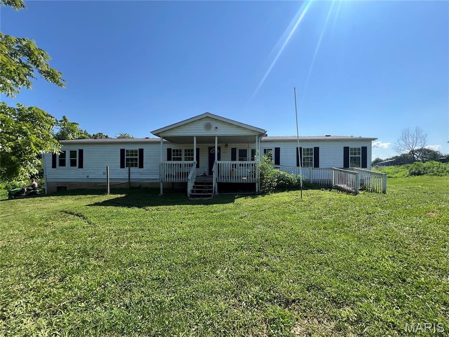 View of front of home featuring a front yard and covered porch