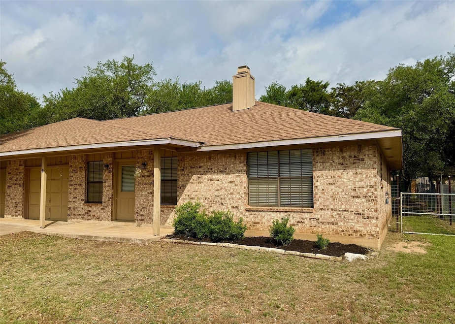 Single story home featuring a chimney, brick sidi