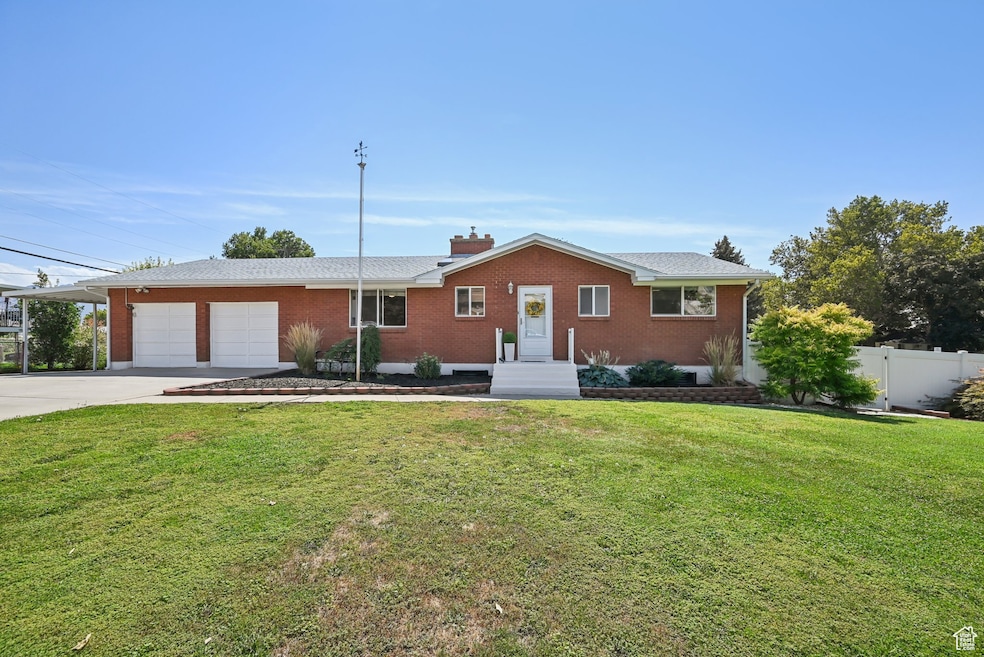 Ranch-style home featuring an attached garage, driveway, brick siding, and a chimney