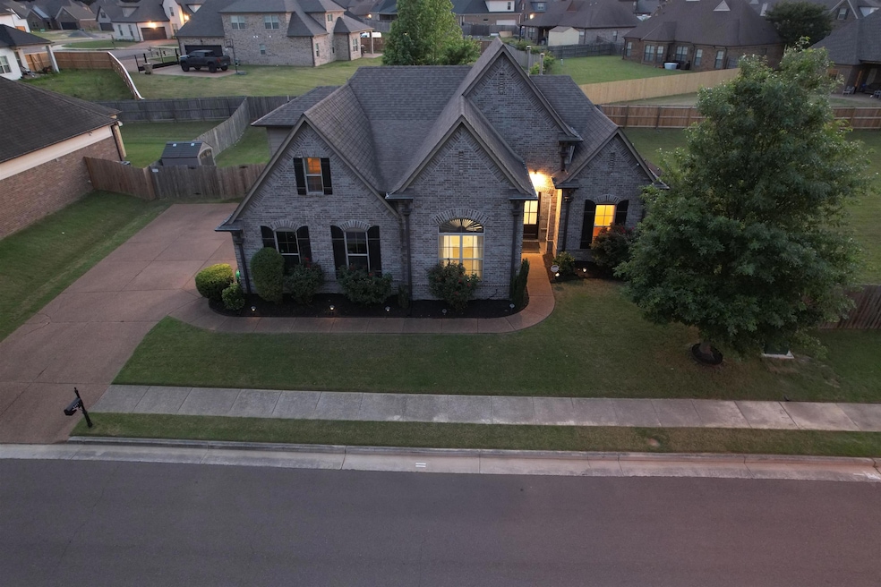French country inspired facade featuring a residential view, brick siding, stone siding, a shingled roof, and concrete driveway