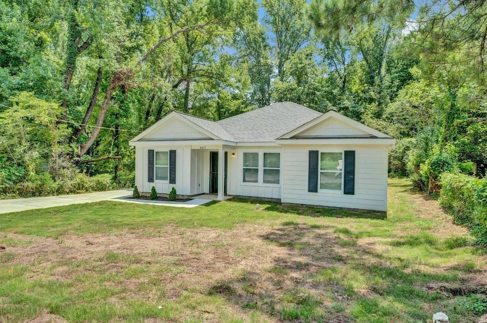 Ranch-style home with board and batten siding, a front yard, and roof with shingles