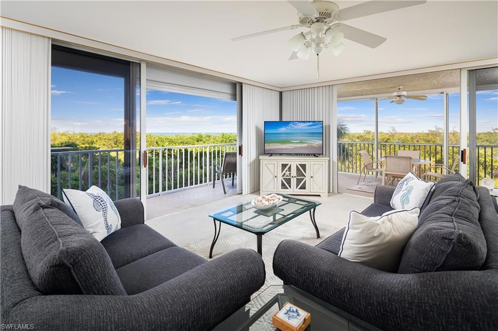 Carpeted living room with expansive windows, ceiling fan, and plenty of natural light