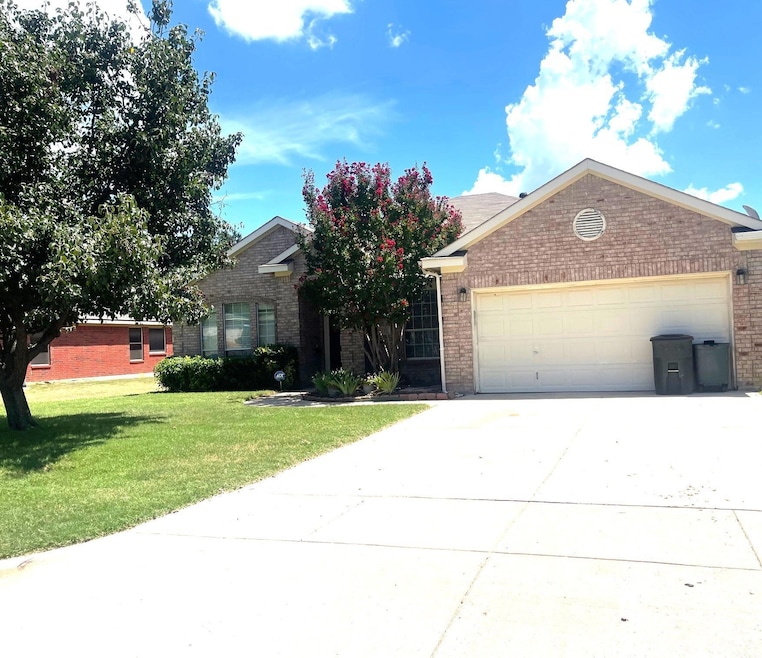 View of front of house with a front yard and a gar