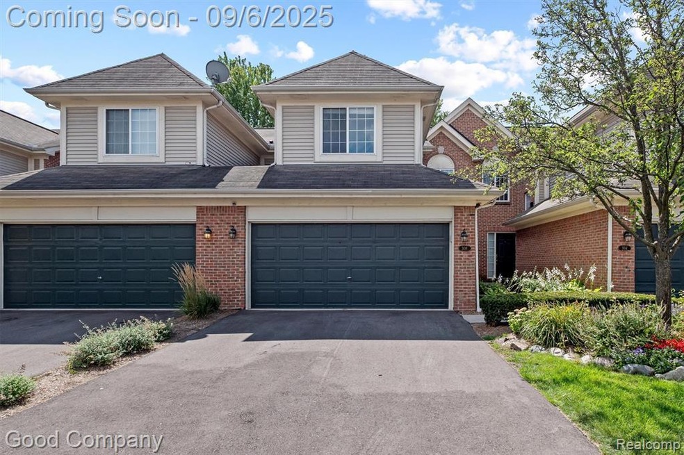 Traditional home with driveway, an attached garage, brick siding, and a shingled roof